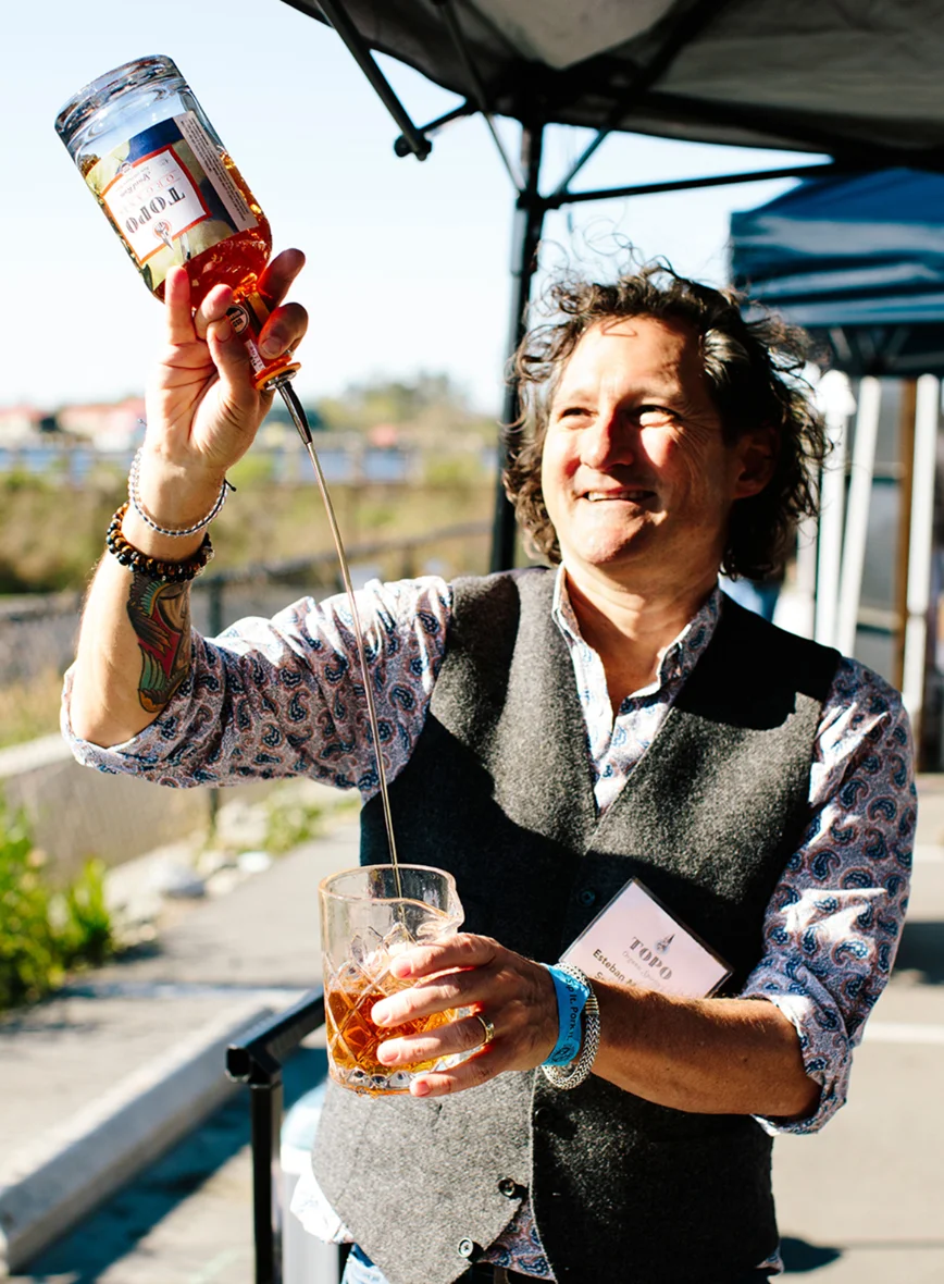 A pourer serving wine at a festival tasting bar