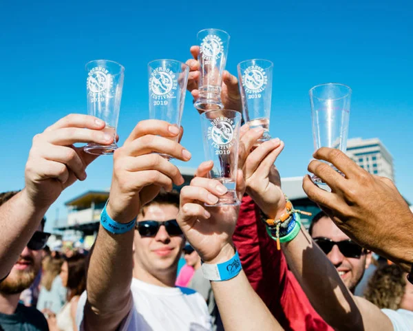 Guests raising branded festival glasses in a toast